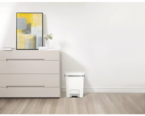 Scène avec commode, image, vase à fleurs et poubelle à pédale