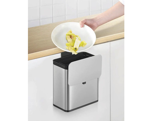 Einbau Abfalleimer aus Edelstahl mit Abdeckung und einer Person die Abfälle entsorgt.