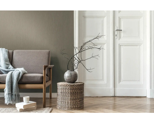 Wohnzimmer mit Sofa, Beistelltisch aus Korbgeflecht und weißer Tür