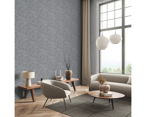 Wohnzimmer mit grauer Tapete mit Blattmuster, Sofa, Sessel und Holztischen.