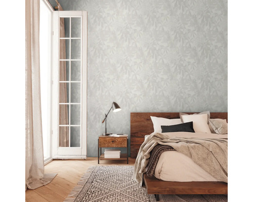 Chambre avec lit double, table de chevet, lampe et papier peint à motifs