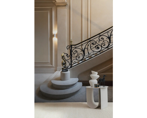 Escalier élégant avec rampe décorative et sculptures sur socles ainsi qu''une table d''appoint avec des vases.