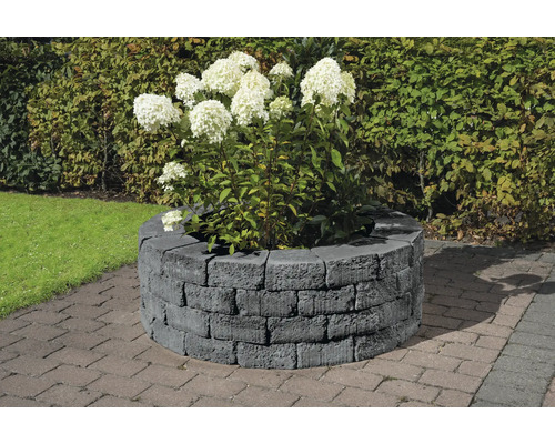 Jardinière ronde en pierres de béton avec plantation d''hortensias dans le jardin