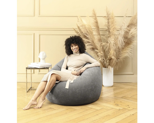 Frau sitzt in einem grauen Sitzsack in einem hellen Raum