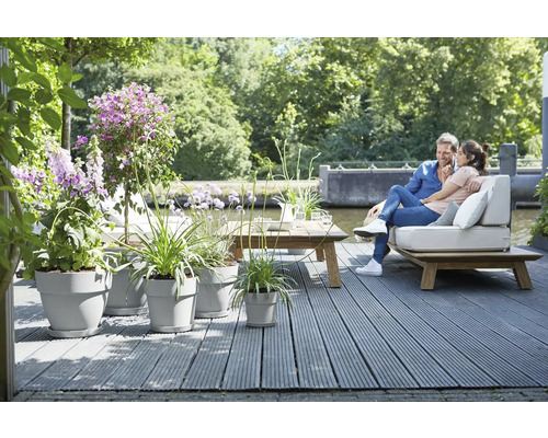 Terrasse avec plancher en bois, pots de fleurs et couple sur un banc