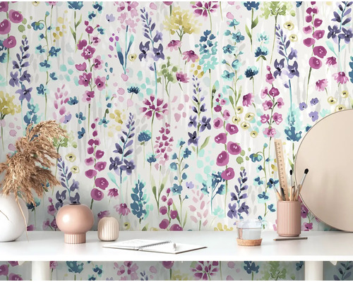 Szene mit Blumenmuster-Tapete, Schreibtisch, Deko und Büromaterialien.