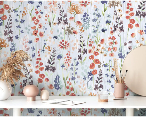 Szene mit floraler Tapete, Schreibtisch, Dekorationen und Schreibwaren.