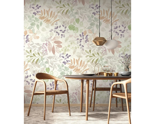 Une salle à manger avec un papier peint floral à motifs de feuilles dans différentes nuances, une table en bois avec des chaises et des suspensions.