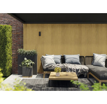 Terrassenszene mit Lounge-Möbeln, Pflanzen und Holzverkleidung für den Aussenbereich.