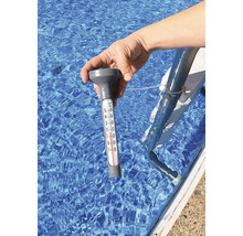 Une main tient un thermomètre de piscine dans l''eau.
