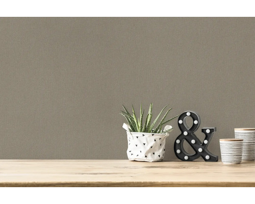 Dekoratives Arrangement mit Pflanze, Lampe und Tassen vor einer einfarbigen Wand