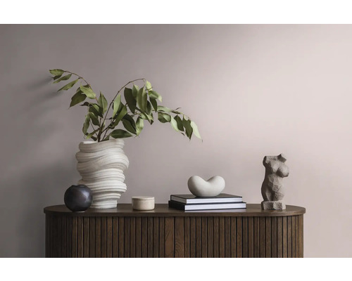 Dekoratives Arrangement auf einem Holzschrank mit einer gewundenen Vase, Blättern, einer weiblichen Torsoskulptur und Büchern