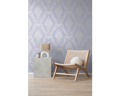 Dekorative Tapete mit Ornamentmuster im Wohnraum mit Lampe und Sessel