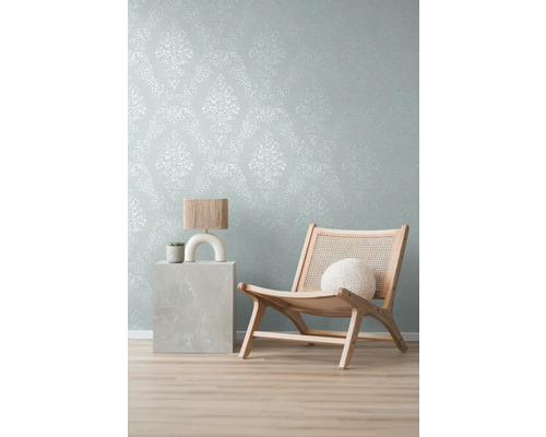 Dekorative Tapete mit Muster, Lampe und Holzstuhl im Raum.