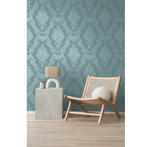 Pièce décorative avec papier peint à motifs, fauteuil en bois et table d''appoint