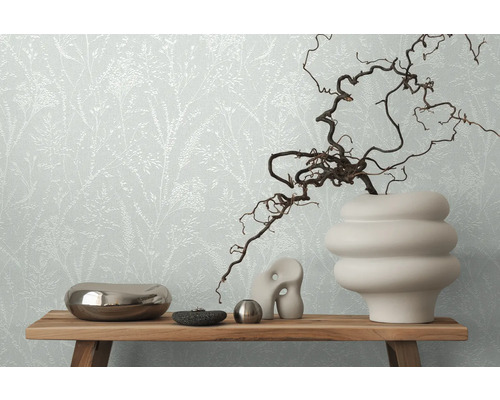 Dekoratives Stillleben mit Blumentapete im Hintergrund, arrangiert auf einem Holztisch.