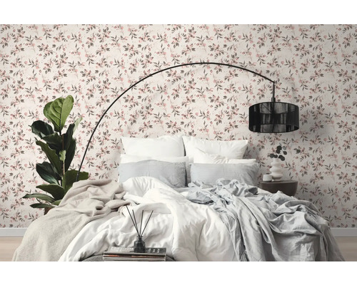 Schlafzimmer mit Bett vor einer Wand mit Blumentapete