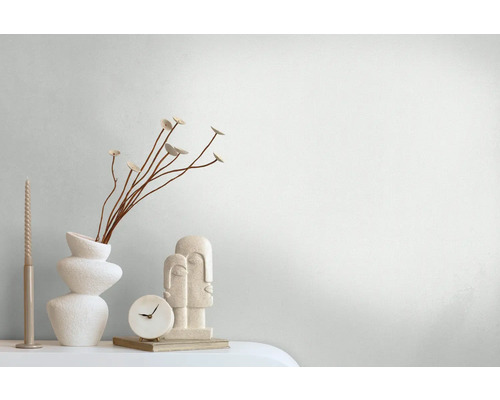 Dekorative Szene mit Vase, Zierblumen, Kerze, Tischuhr und Skulptur auf einem Tisch