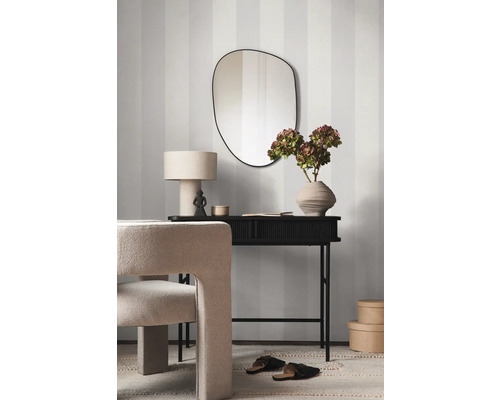 Dekoratives Interieur mit Spiegel, Tisch, Lampe, Stuhl und Blumenvase vor einer gestreiften Wand