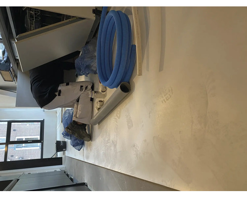 Un artisan installe un lave-vaisselle dans une cuisine.