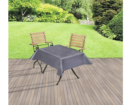 Aménagement de jardin avec table, chaises et nappe grise sur une terrasse