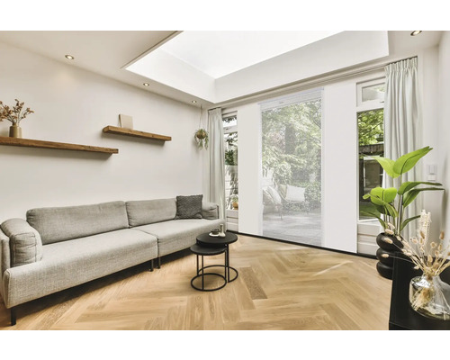 Salon avec canapé, table basse, étagères en bois et stores enrouleurs