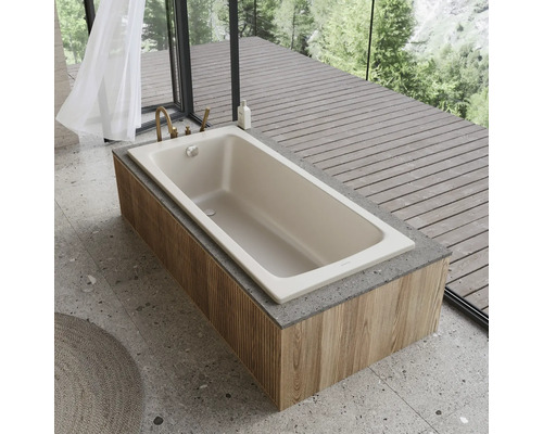 Beige Badewanne mit Holzverkleidung und Armatur in einem hellen Badezimmer