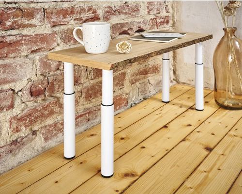 Table avec plateau en bois et pieds réglables en hauteur, avec tasse, carnet et décoration dessus