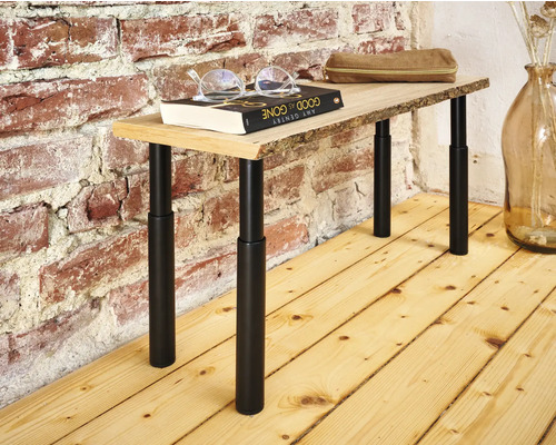 Table avec plateau en bois et pieds en métal réglables devant un mur en briques