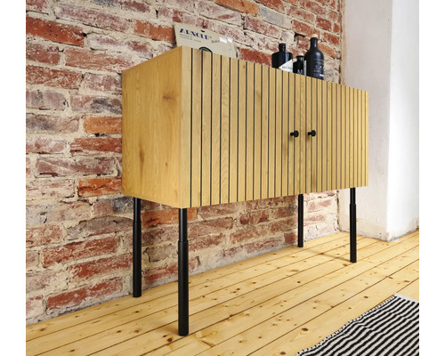 Buffet en bois avec portes et pieds en métal devant un mur en briques