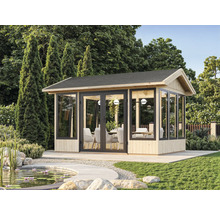 Pavillon de jardin avec façade en verre et coin salon dans un environnement verdoyant