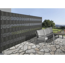 Gartenszene mit Sichtschutzzaun aus Kunststoff mit dekorativen Mustern, Gartenmöbeln und Steinboden