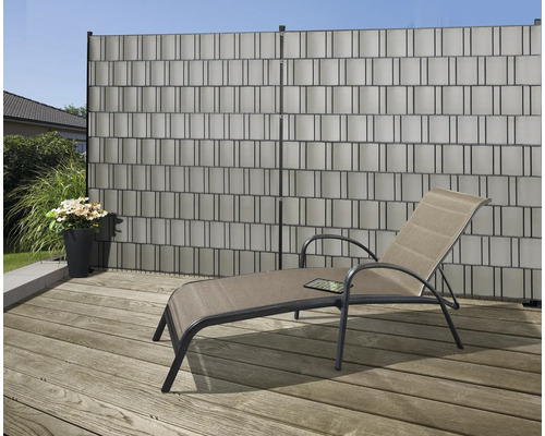 Sichtschutzzaun aus Kunststoff mit Liegestuhl auf einer Terrasse