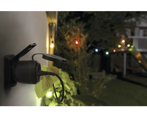 Aussensteckdose mit eingestecktem Stecker im Garten