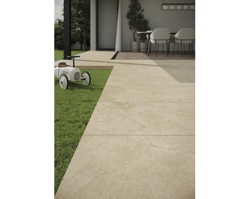Terrassenplatten aus Stein auf einer Terrasse mit Rasenfläche und Spielzeugauto.