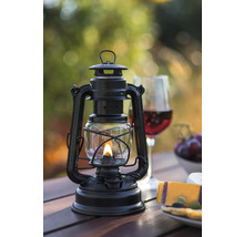 Lampe à pétrole noire sur une table en bois avec des collations et des boissons