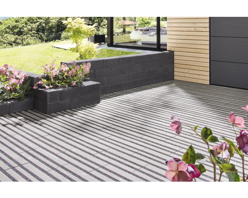 Terrasse avec des blocs de plantation et un motif de pavage linéaire dans le jardin