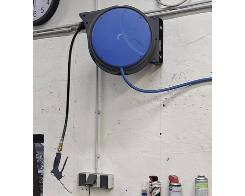 Druckluftschlauchaufroller mit Druckluftpistole an einer Werkstattwand