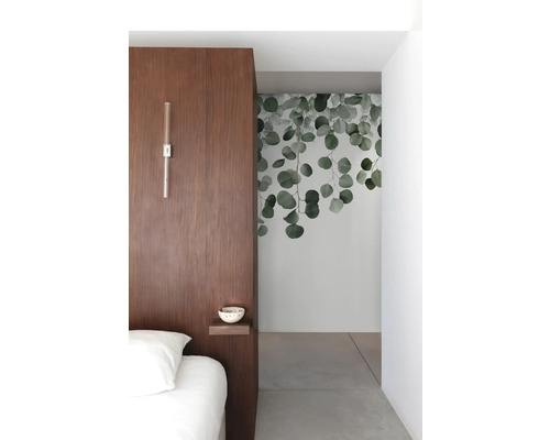 Chambre à coucher avec mur en bois, applique murale, petite étagère et peinture murale avec motifs d''eucalyptus.