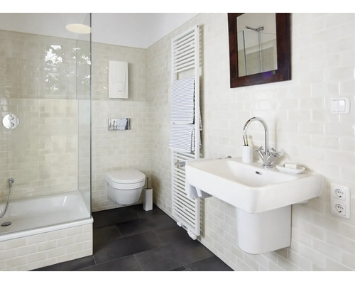 Badezimmer mit Badewanne, Toilette, Handtuchwärmer und Waschbecken