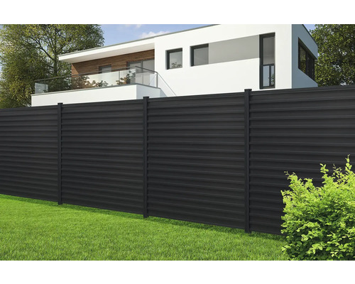 Dunkler Metallzaun vor einem Haus mit Rasenfläche