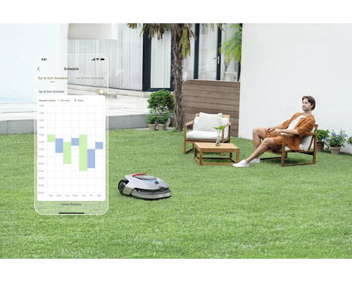 Robot tondeuse avec commande par application dans le jardin, tandis qu''une personne se détend