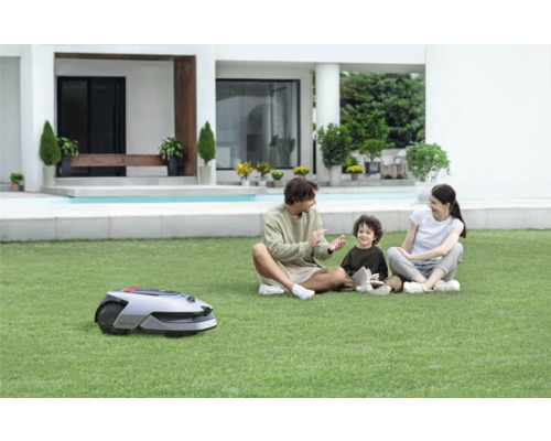 Scène avec une famille dans le jardin et un robot tondeuse