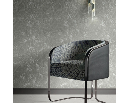 Szene mit einem Sessel mit Blätterdesign vor einer gemusterten Tapete