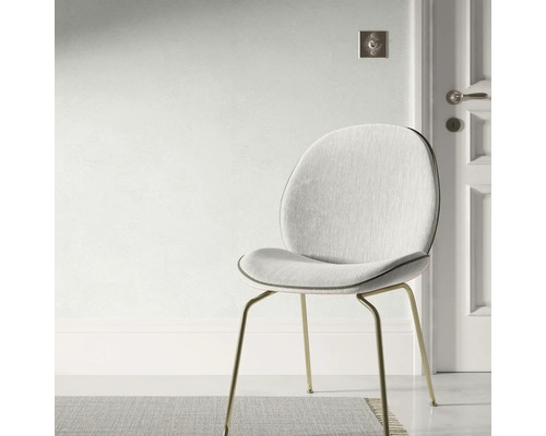 Chaise rembourrée avec pieds en métal devant un mur et une porte