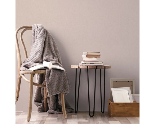 Szene mit Holzstuhl, Decke, Buch und Beistelltisch mit Büchern