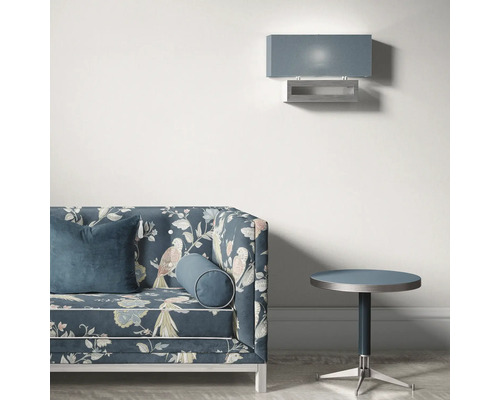 Szene mit einem Sofa mit Vogelmuster, einem runden Beistelltisch und einer Wandleuchte