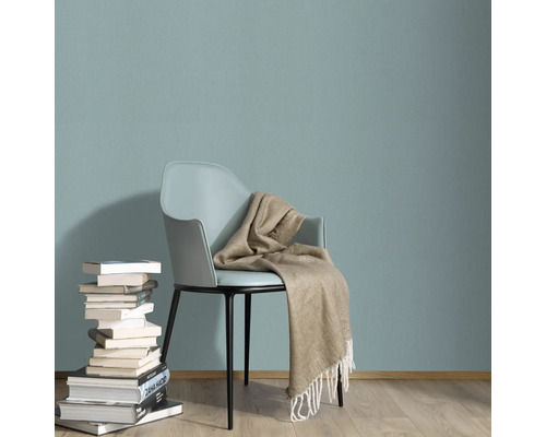 Szene mit Stuhl, Bücherstapel und Decke vor einer Wand