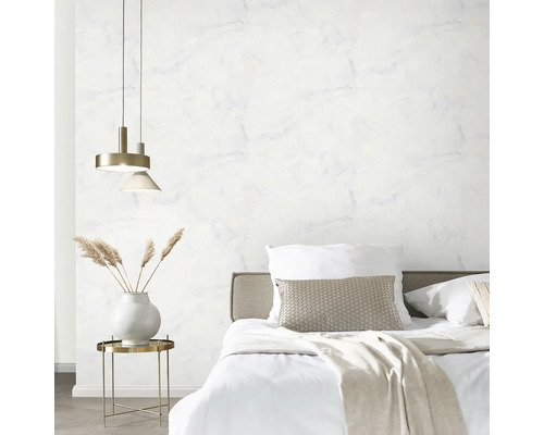 Schlafzimmer mit Bett, Nachttisch und Marmorwand