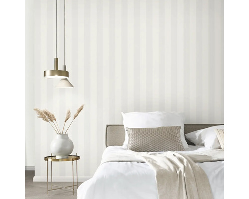 Schlafzimmer mit Bett, Lampe und gestreifter Tapete